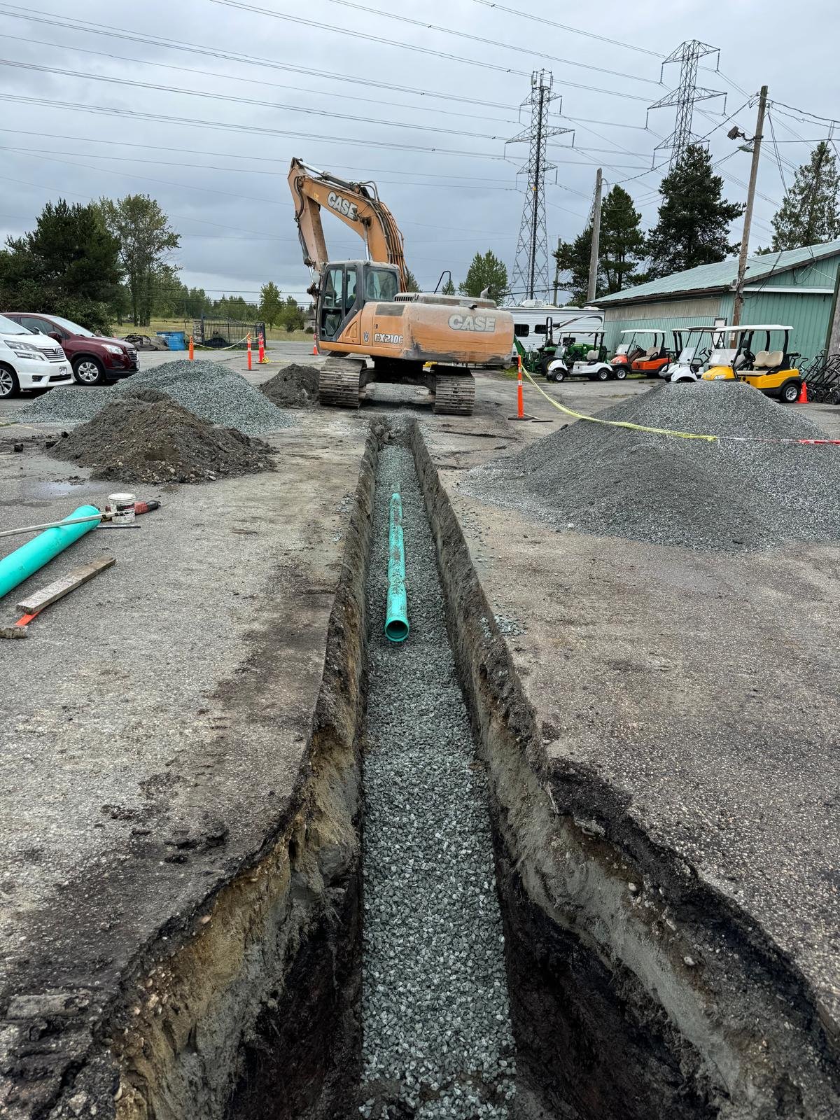 Green PVC drainage pipe being installed in trench